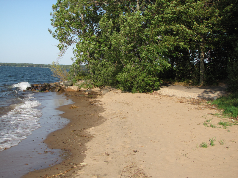 Leave the beach and follow the paved path left along the shore